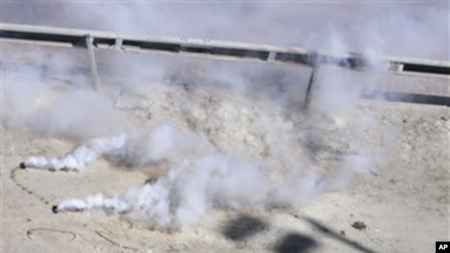 Bahraini protester runs away after riot police fired tear gas at protesters at the Pearl roundabout soon after the military pulled out in Manama, Bahrain, February 19, 2011 (file photo)