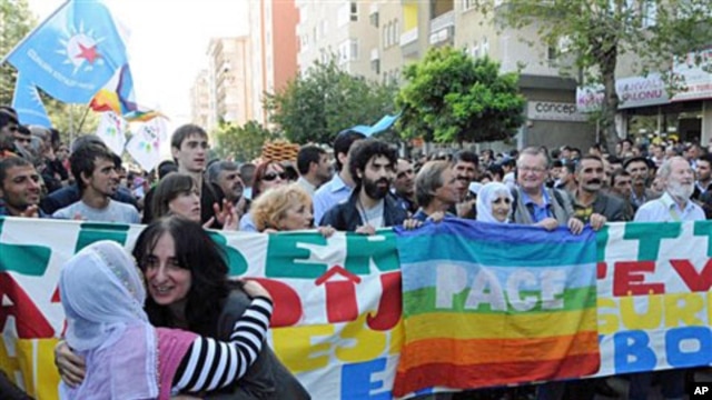 People demonstrate in support of Kurdish politicians near a courthouse where more than 150 Kurds, including a dozen elected mayors, went on trial in Diyarbakir, 18 Oct 2010