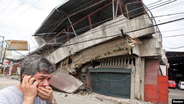 Un residente pasa frente a una casa colapsada durante un terremoto en la ciudad de Cebu, en el centro de las Filipinas.