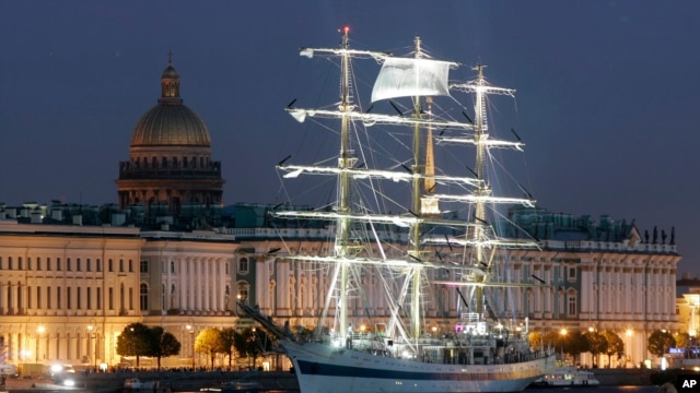 The Russian tall ship Mir (Peace) sails along the Neva River with the Hermitage (Winter Palace) in the background.