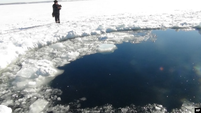 A circular hole in the ice of Chebarkul Lake where a meteor reportedly struck the lake near Chelyabinsk, about 1500 kilometers (930 miles) east of Moscow,  February 15, 2013