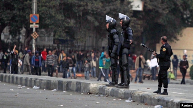 Riot police try to stop clashes and ask protesters, opposing Egyptian President Mohamed Mursi, to back away along Qasr Al Nil bridge, which leads to Tahrir Square in Cairo, Mar. 7, 2013. 