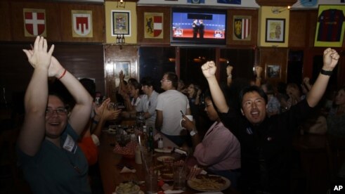 Mariella Roque, 21, of Miami, left, and Jorge Palamino, 24, of Miami, right, supporters of Republican presidential candidate Mitt Romney, cheer as they watch a televised debate between Romney and President Barack Obama in Coral Gables, Florida.