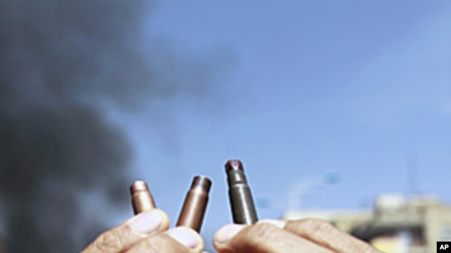 An anti-government protester displays spent bullet cases during a demonstration demanding the ouster of Yemen's President Ali Abdullah Saleh in the southern city of Taiz, May 11, 2011
