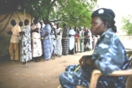 A police officer watches as women queue to vote during the recent referendum on South Sudan's independence. (April 2011)