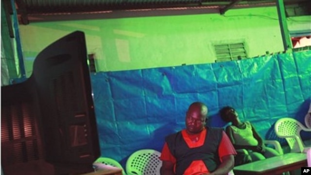 Owner of an open-air bar and restaurant Zakarya Gueme takes notes as partial election results are announced on state television, in central Bouake, the former rebel capital of northern Ivory Coast, 02 Nov 2010