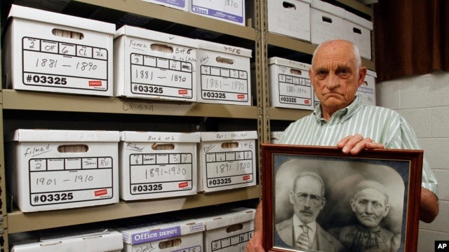 Jack Goins poses with a photo dated to have been taken in 1898 of his great-great grandparents found through genealogical research, May 23, 2012.