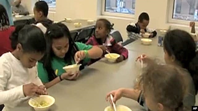 Students in the Kids Cafe after-school program learn about the nutritious value of an avocado while making an avocado and bean dip.