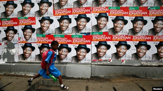 A schoolgirl walks past campaign posters in support of Nigeria's President Goodluck Jonathan along a road in Ikoyi district in Lagos, Feb. 13, 2015. 