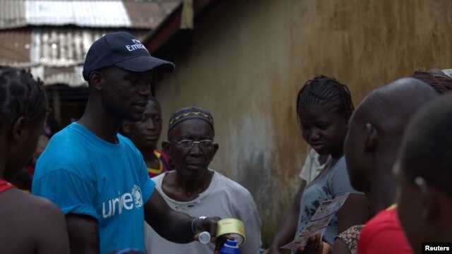 Một nhân viên của UNICEF chia sẻ thông tin với cư dân ở Conakry, Guinea về Ebola và những phương pháp tốt nhất để ngăn ngừa sự lan tràn của căn bệnh này.