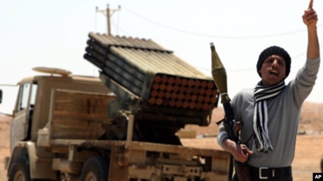 A Libyan rebel fighter shouts slogans as he welcomes comrades heading towards the front line outside the Libyan eastern city Ajdabiya on May 10, 2011.