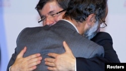 Թուրքիայի արտգործնախարար Դավութօղլուն շնորհավորում է Սիրիայի ազգային դաշինքի ղեկավար Մուազ ալ-Խաթիբին, Դոհա, Քաթար, 2012թ. նոյեմբերի 11