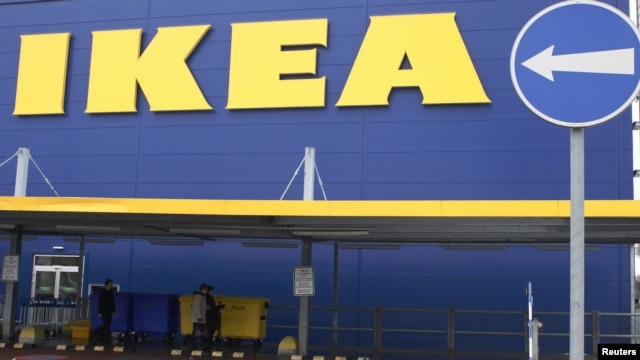 People walk alongside an IKEA outlet in Prague, Feb. 25, 2013.