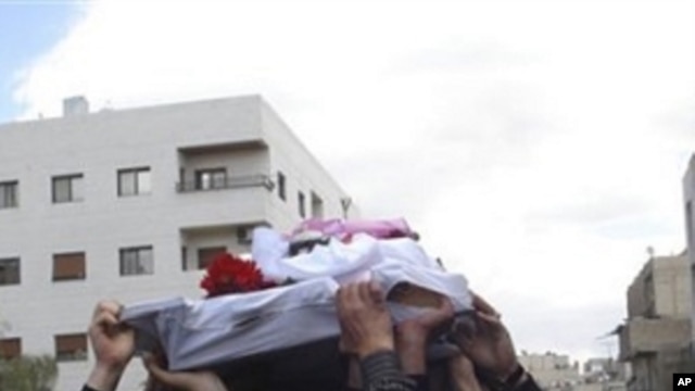 Syrian anti-government protesters carry the coffin of an activist who was killed on Friday during his funeral procession in Quaboun near Damascus, Syria (File Photo)
