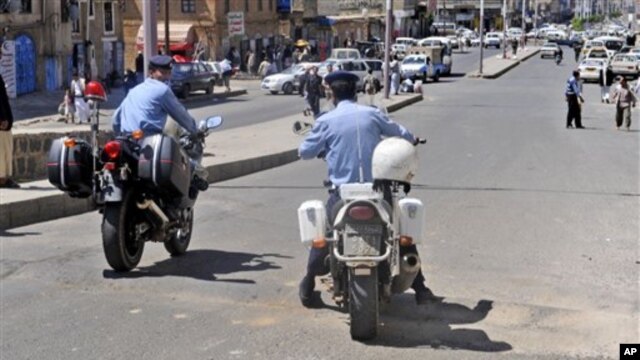 Yemeni policemen attend the scene where an attack took place on a convoy carrying a senior British diplomat in San'a, Yemen, 6 Oct 2010