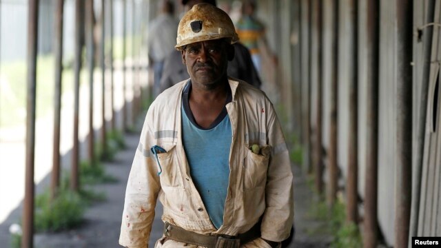 Miners walk at the end of their shift at the Anglo Platinum's Khuseleka shaft 1 mine in Rustenburg, northwest of Johannesburg, January 15, 2013.