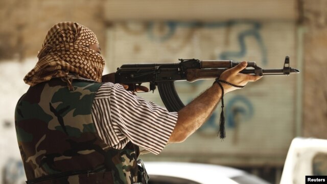 Một chiến binh của Quân đội Syria Tự do chiến đấu trong thành phố Aleppo, 31/7/12