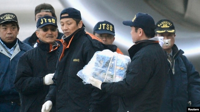 A Japanese investigator carries a battery which was taken from the All Nippon Airways' (ANA) 787 Dreamliner plane, which made an emergency landing on Wednesday, at Takamatsu airport in Takamatsu, in this photo taken by Kyodo, January 17, 2013. 