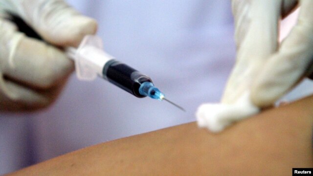 A health worker collects blood from a patient at an HIV/AIDS consulting centre while U.S. Health Secretary Mike Leavitt visits the centre in Vietnam's northern Hai Phong City, 92 km east of Hanoi October 15, 2005. 