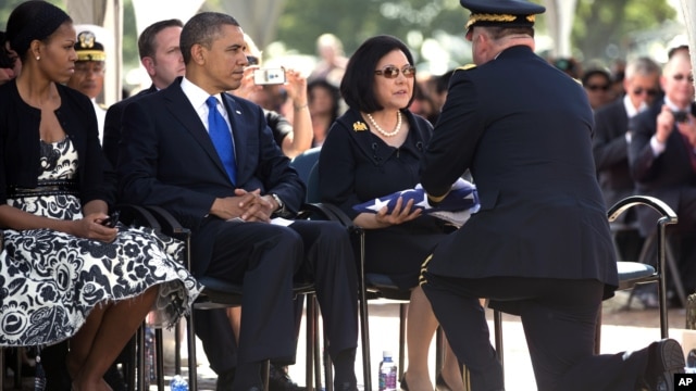 President Barack Obama and First Lady Michelle Obama look on from left as Irene Hirano Inouye, the widow of the late Sen. Daniel Inouye, is given the flag that was draped over her husband's casket during a  memorial service at the National Memorial Cemete