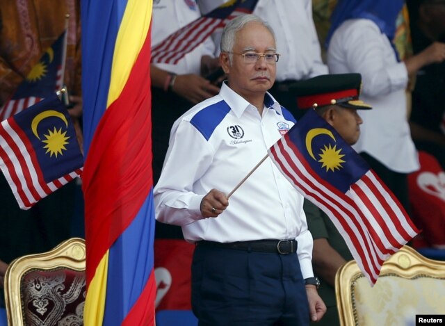 Malaysia's Prime Minister Najib Razak waves a Malaysian national flag during National Day celebrations in Kuala Lumpur, August 31, 2015.