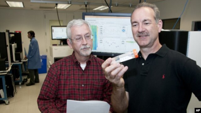 Timothy Ley , MD (left) and Richard Wilson, PhD, looking at a flow cell in the genome sequencing lab. They and their Washington University colleagues have shown the power of sequencing cancer patients' genomes as a diagnostic tool.