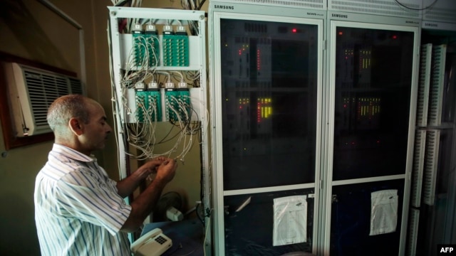 A Syrian techinician works to set a new telephone network in the city of Qusayr, in Syria's central Homs province, Aug. 1, 2013.