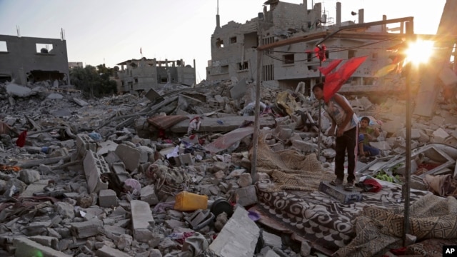 Ahmad and Mahmoud al Masri are seen on the rubble of their family house destroyed by Israeli strikes in the town of Beit Hanoun, in the northern Gaza Strip, Aug. 12, 2014. 