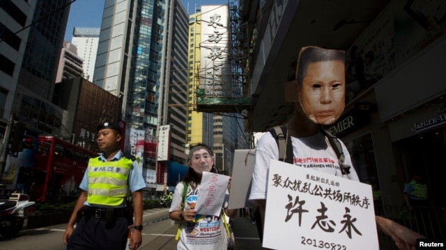 香港民主派抗议者戴着象征许志永的面具在香港街头抗议，要求中国释放政治犯。（2013年10月1日）