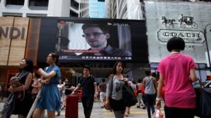 ေဟာင္ေကာင္ ၿမိဳ႕လယ္ေနရာတခုမွာ Snowden အေၾကာင္း တီဗြီဖန္သားျပင္ေပၚမွာျပသေနစဥ္။ (ဇြန္လ ၂၃ ရက္၊ ၂၀၁၃)။