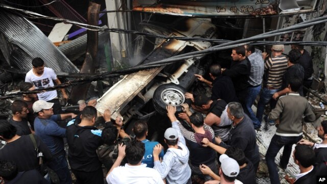 This photo released by the Syrian official news agency SANA shows Syrians pushing a car at the scene after a blast in Damascus, Syria, November 5, 2012. 