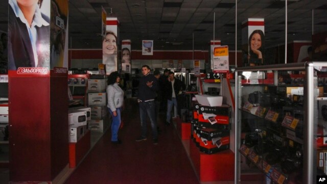 Customers are seen standing in an electronics store after a power failure, in Simferopol, Crimea, Nov. 22, 2015.