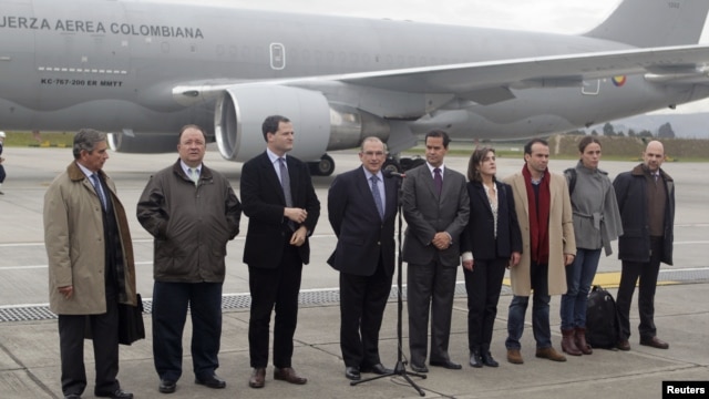 Colombia's government head of negotiators Humberto de la Calle (C) speaks next to delegation members prior to boarding a plane to Oslo, at a military airport in Bogota October 16, 2012. Colombia's government and Marxist rebels will start peace talks as pl