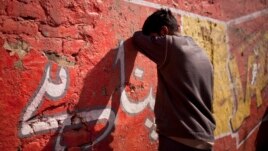 A drug addict leans on a wall after injecting himself with a dose of heroin on a street in Rawalpindi, Pakistan, Feb. 14, 2012.