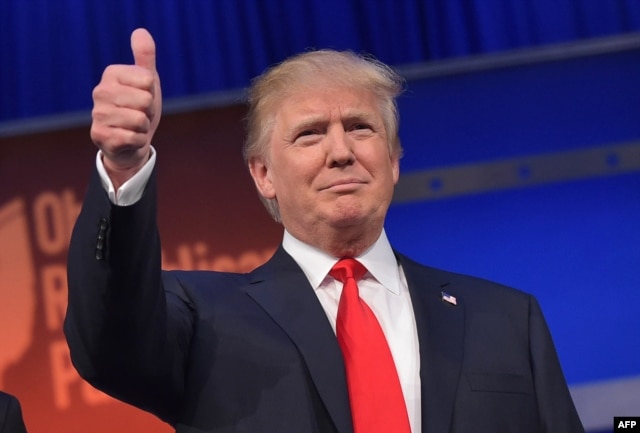 Real estate tycoon Donald Trump flashes the thumbs-up as he arrives on stage for the start of the prime time Republican presidential debate on Aug. 6, 2015 at the Quicken Loans Arena in Cleveland, Ohio.