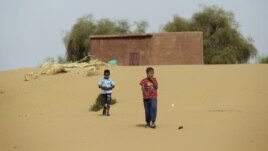 Boys walk on desert sands in the town of Moghtar-Lajjar in west Africa's Sahel region, where the United Nations says civil unrest and a drought  have put 18 million people in food insecurity, May 25 2012.