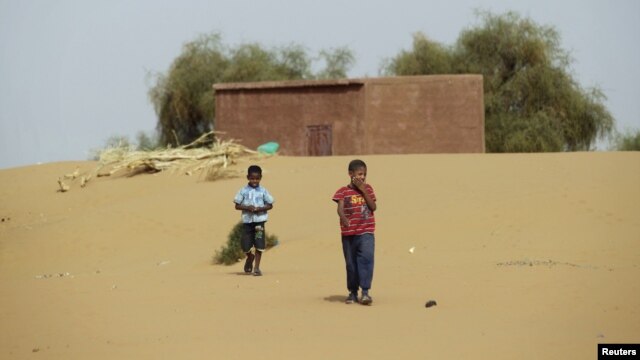 Boys walk on desert sands in the town of Moghtar-Lajjar in west Africa's Sahel region, where the United Nations says civil unrest and a drought  have put 18 million people in food insecurity, May 25 2012.