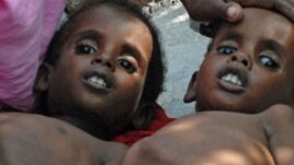 Two Somali children suffering from malnutrition lie at a camp for internally displaced people near Mogadishu airport, July 18, 2011.