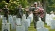 Soldiers salute as "Taps" is played during a military funeral nearby as they were placing flags on graves at Arlington National Cemetery in Virginia May 23, 2013.