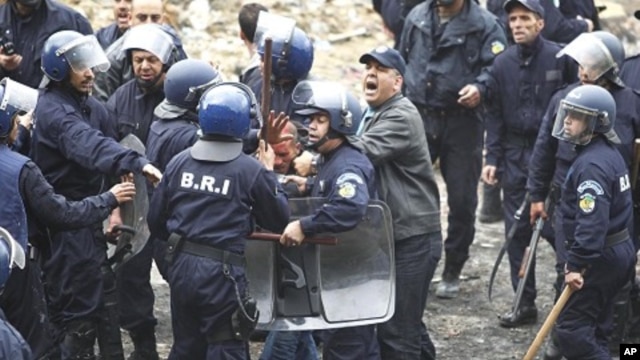 Riot policemen detain a protester during a demonstration in Oued Koriche, Algiers, March 23, 2011