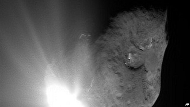 This image provided by NASA shows comet Tempel 1 at the moment of impact with NASA's Deep Impact probe as it smashed into its surface. The probe crashed between the two dark-rimmed craters near the center and bottom of the comet (File Photo - July 4, 2005