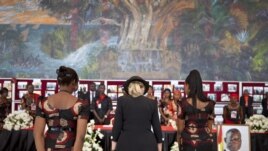 U.S. Secretary of State Hillary Clinton, center, pays her respects after signing the guest book for Ghana's late President John Atta Mill's funeral in Accra, Ghana, August 10, 2012.