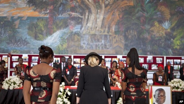 U.S. Secretary of State Hillary Clinton, center, pays her respects after signing the guest book for Ghana's late President John Atta Mill's funeral in Accra, Ghana, August 10, 2012.