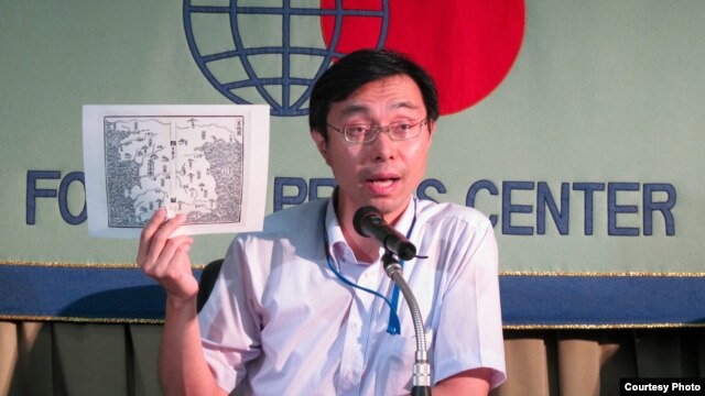 Masaru Sato, Assistant Press Secretary at the Japanese Ministry of Foreign Affairs, holding a 16th-century map of Korea to explain Japan's claim to the island of Takeshima, August 22, 2012. (VOA/Miguel Quintana)