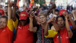 People pray during a demonstration in support of Venezuela's President Hugo Chavez at the Simon Bolivar Square in Caracas, Venezuela, Sunday, Dec. 9, 2012.