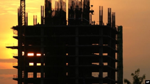 Construction workers work on a new building in Phnom Penh. Cambodia is embracing a thriving real estate market, where land and housing prices in the capital city skyrocket with no sign of letting up, file photo. 