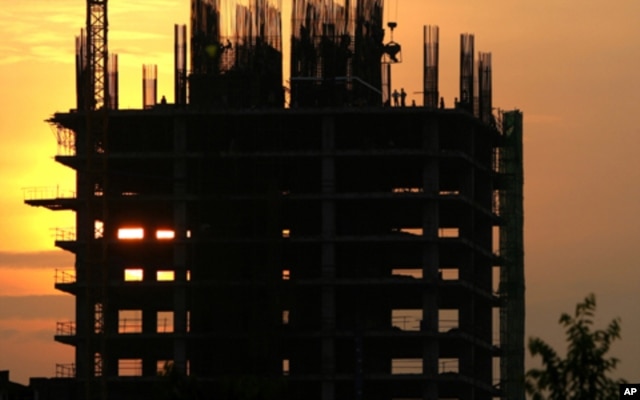 FILE - Construction workers work on a new building in Phnom Penh, Cambodia