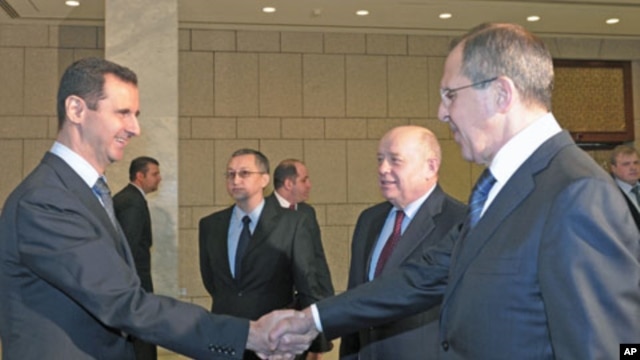 Syrian President Bashar al-Assad (L), shakes hands with Russian Foreign Minister Sergey Lavrov (R), as Russian Foreign Intelligence chief Mikhail Fradkov (2nd R) looks on during their meeting in Damascus, Syria, February 7, 2012.
