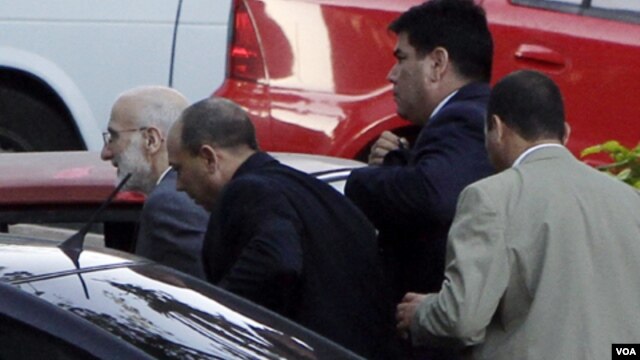 Alan Gross (izq.) cuando era llevado a juicio en marzo de 2011 por agentes de la seguridad cubana.     