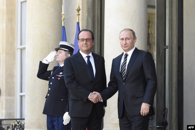French President Francois Hollande (L) shakes hands with Russian President Vladimir Putin upon his arrival at the Elysee Palace, on Oct. 2, 2015, for a peace summit on the Ukraine conflict.